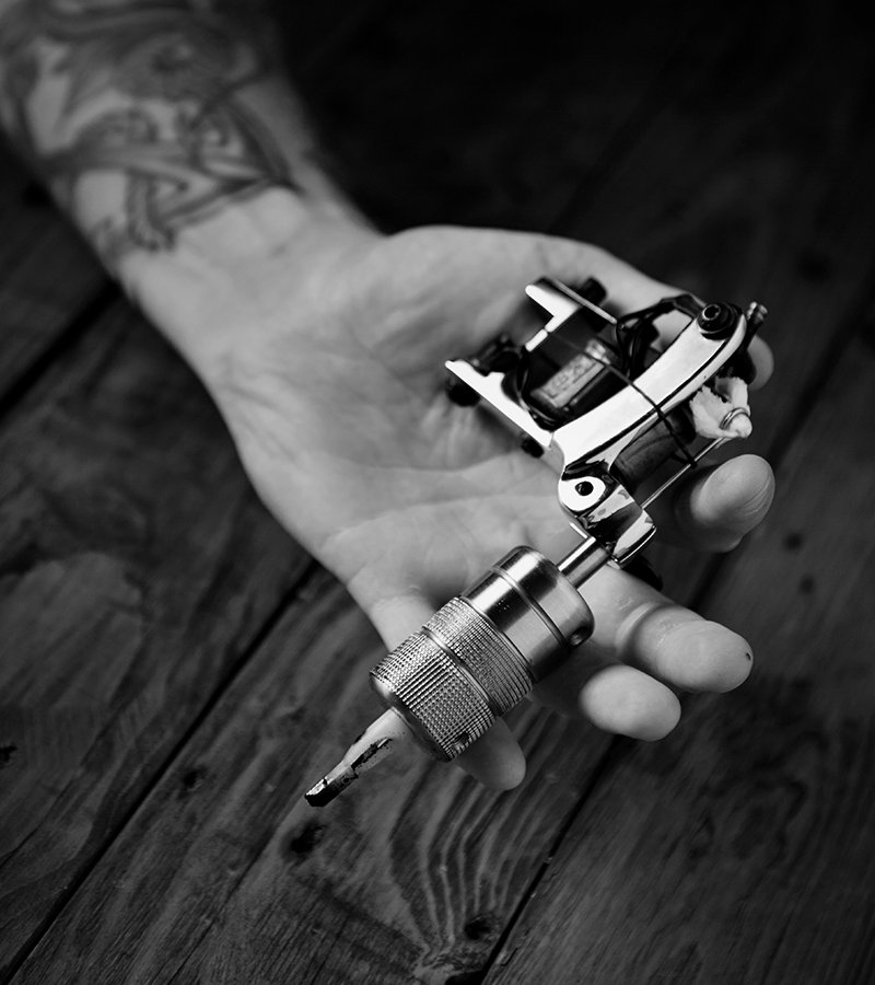 close up of a mans hand with tattoo gun 298DBHB